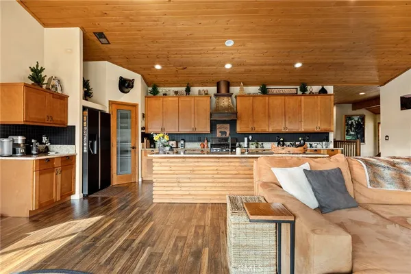 a large kitchen with stainless steel appliances kitchen island granite countertop a refrigerator and a stove top oven