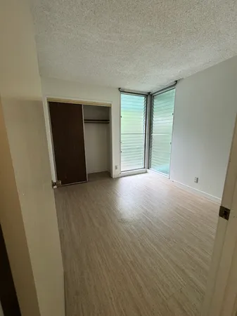 an empty room with wooden floor and closet