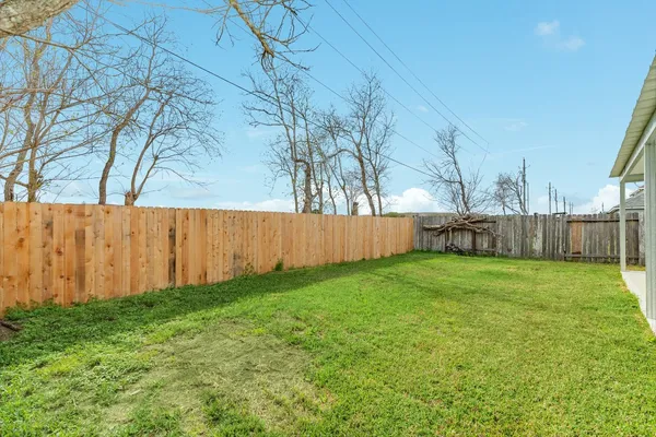 a view of backyard with wooden fence