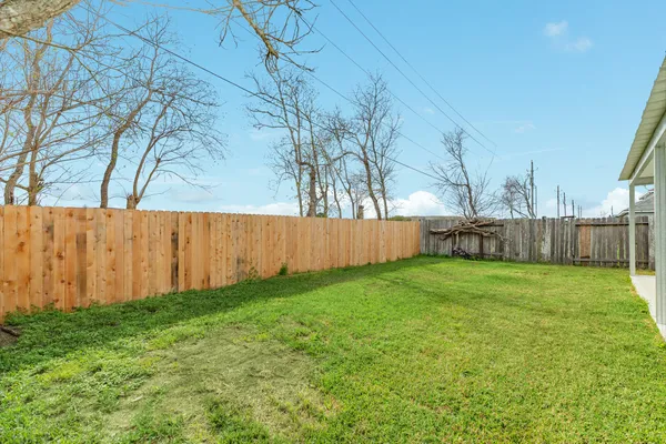 a view of backyard with wooden fence