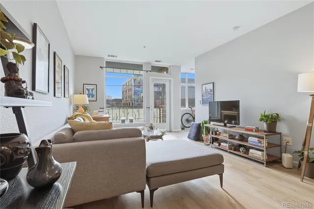 a living room with furniture a flat screen tv and a large window