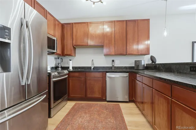 a kitchen with stainless steel appliances granite countertop a refrigerator stove and sink