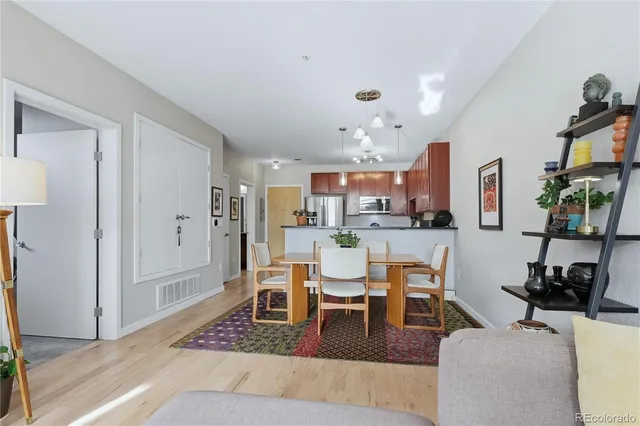 a living room with furniture a rug and kitchen view