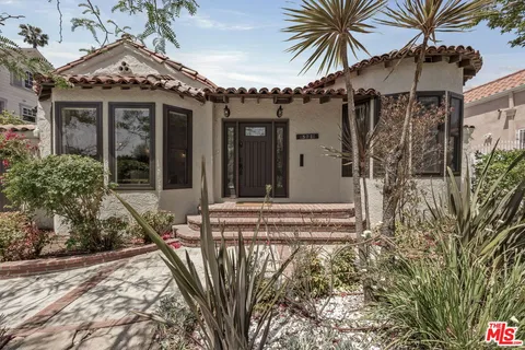 a view of a house with a patio and a yard