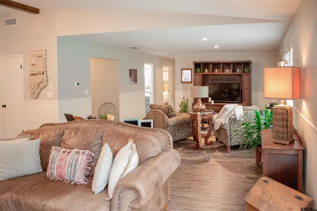 a spacious bedroom with a bed and wooden floor