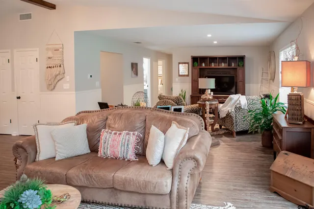 a living room with furniture a large window and a flat screen tv