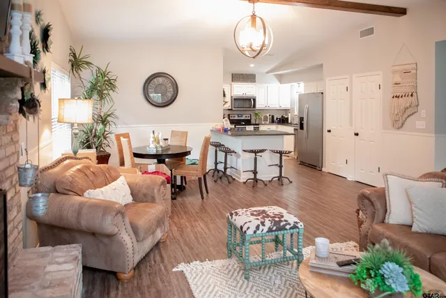 a living room with lots of furniture and view of kitchen