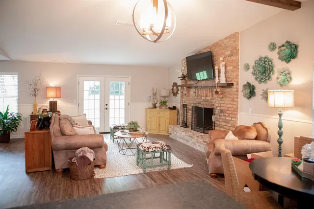 a living room with furniture a flat screen tv and a fireplace