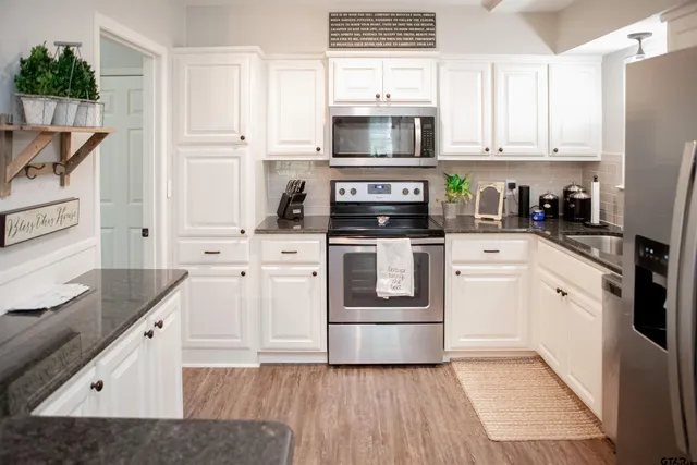 a kitchen with white cabinets and white appliances