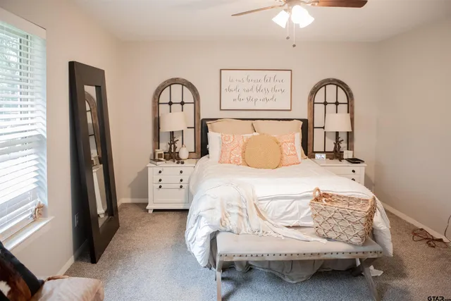 a bedroom with a bed and a large window