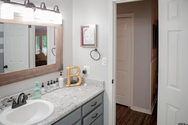 a bathroom with a granite countertop sink and a mirror