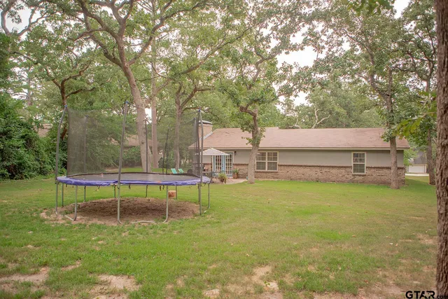 a view of a swimming pool with a bench and trees