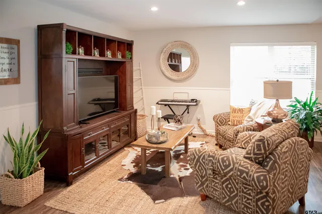 a living room with furniture a flat screen tv and a window