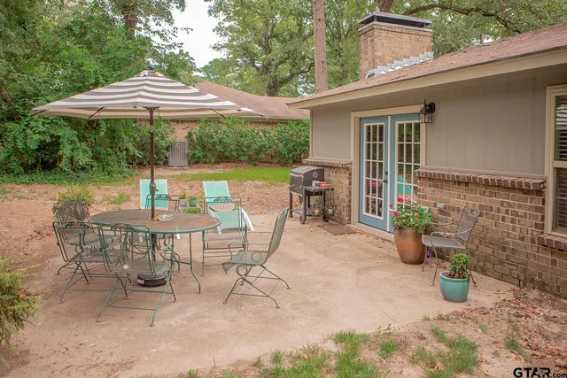 a view of a patio with a table and chairs under an umbrella