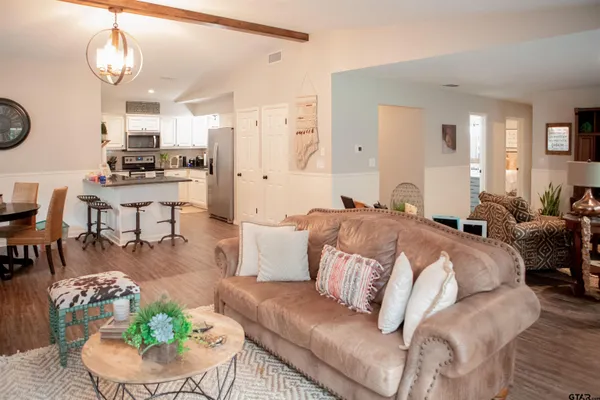a living room with furniture kitchen and a chandelier
