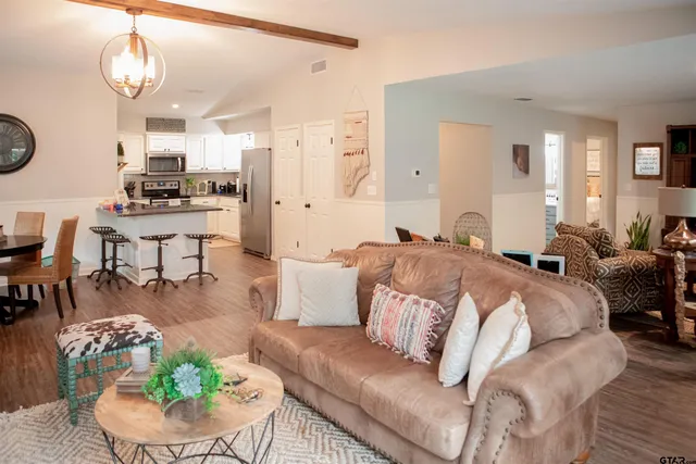 a living room with furniture kitchen and a chandelier