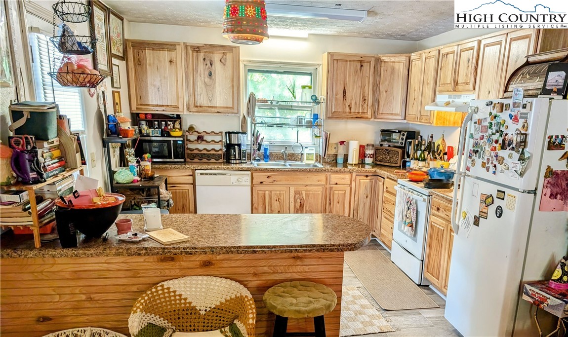 247 Old Bristol Road Boone, NC 28607 - Photo 2 of 5 a kitchen with stainless steel appliances granite countertop a stove a sink dishwasher and cabinets with wooden floor