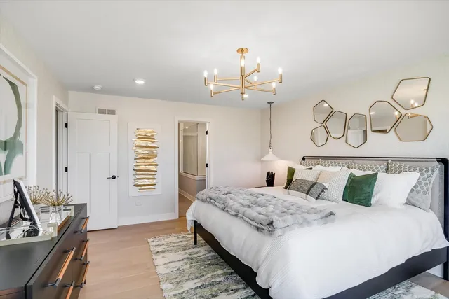 a bedroom with a bed and a chandelier