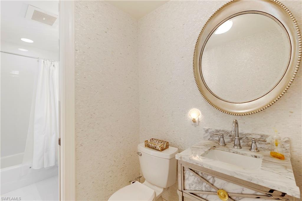 700 La Peninsula Boulevard, Unit 404 Naples, FL 34113 - Photo 31 of 43 a bathroom with a sink mirror vanity and a toilet