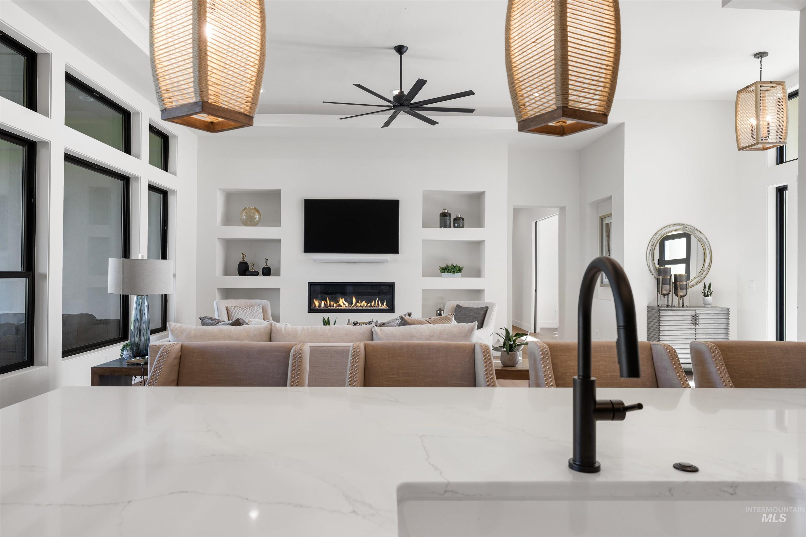 25403 Bur Oak Place Caldwell, ID 83607 - Photo 15 of 46 Living room featuring built in features, a glass covered fireplace, and ceiling fan