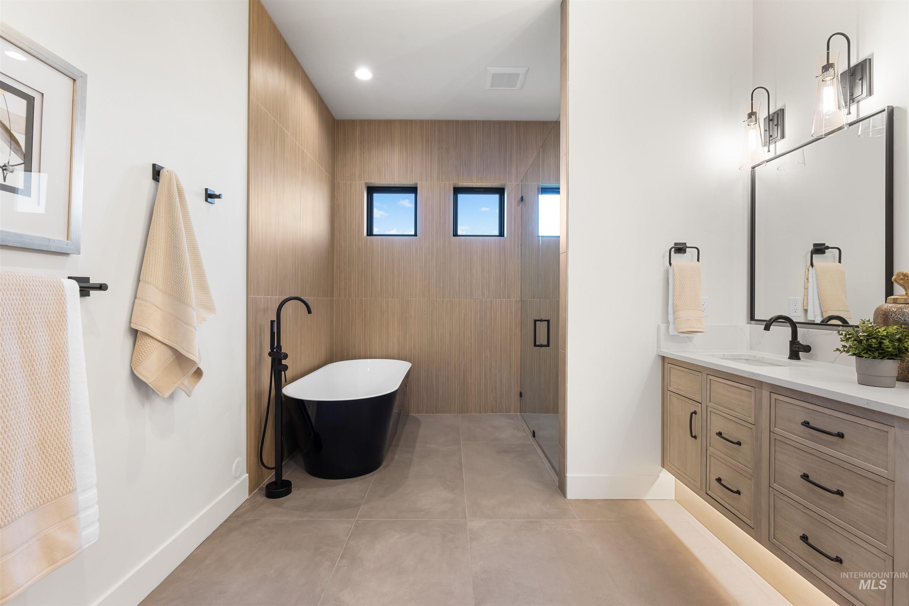 25403 Bur Oak Place Caldwell, ID 83607 - Photo 22 of 46 Full bathroom with vanity, a freestanding tub, a shower stall, tile walls, and recessed lighting