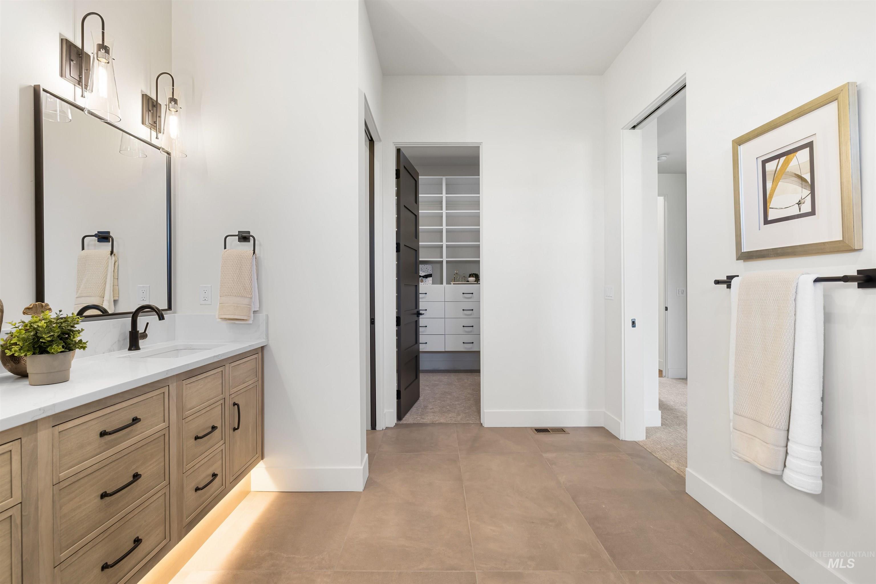25403 Bur Oak Place Caldwell, ID 83607 - Photo 24 of 46 Bathroom with vanity, light tile patterned floors, and a walk in closet
