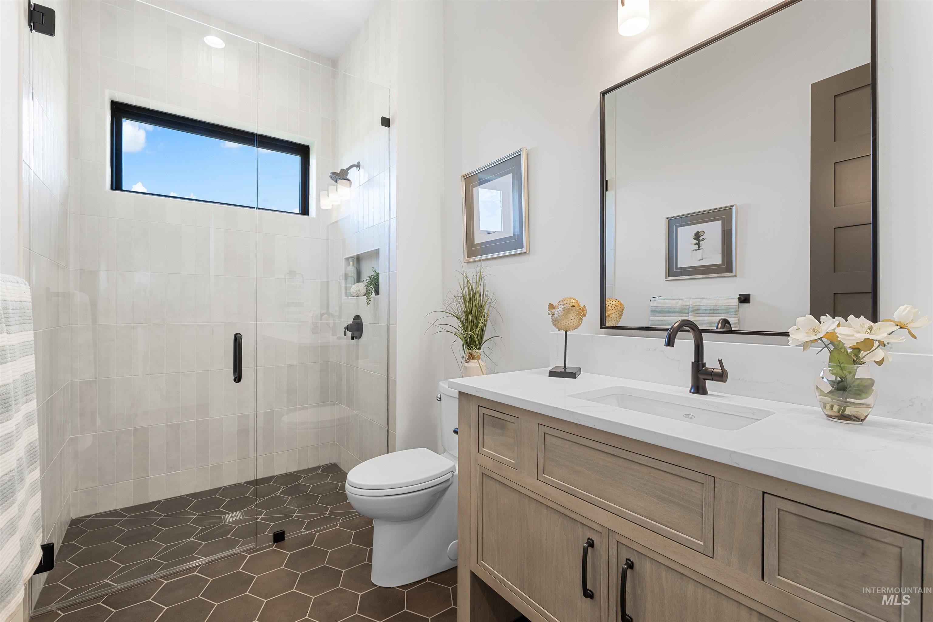 25403 Bur Oak Place Caldwell, ID 83607 - Photo 33 of 46 Bathroom with a stall shower, vanity, and dark tile patterned floors