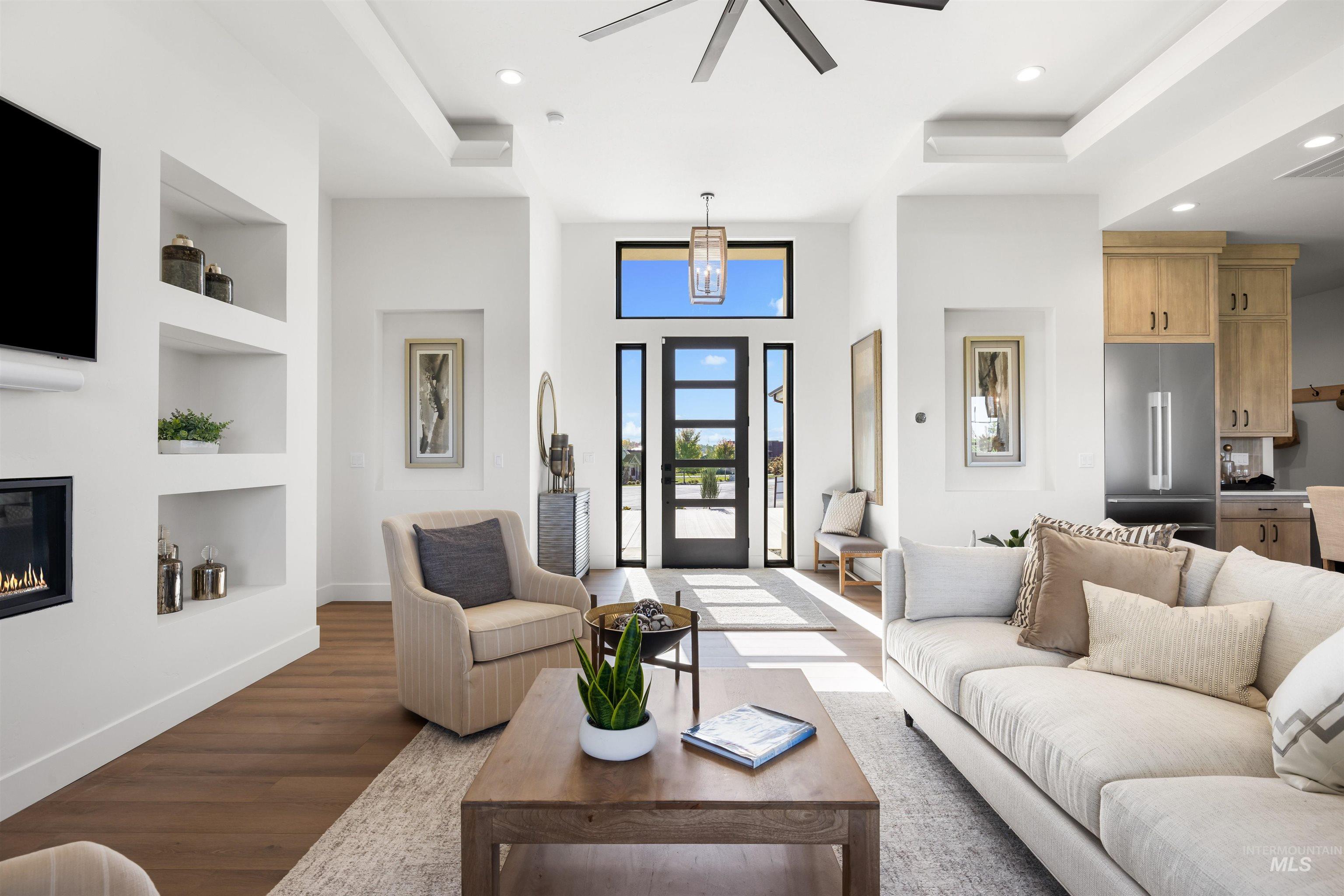 25403 Bur Oak Place Caldwell, ID 83607 - Photo 10 of 46 Living area with recessed lighting, built in features, wood finished floors, a glass covered fireplace, and a ceiling fan