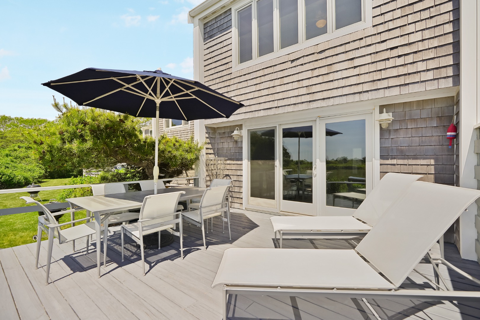 493 Katama Road, Unit E2 Edgartown, MA 02539 - Photo 19 of 29 a view of a patio with a table and chairs under an umbrella