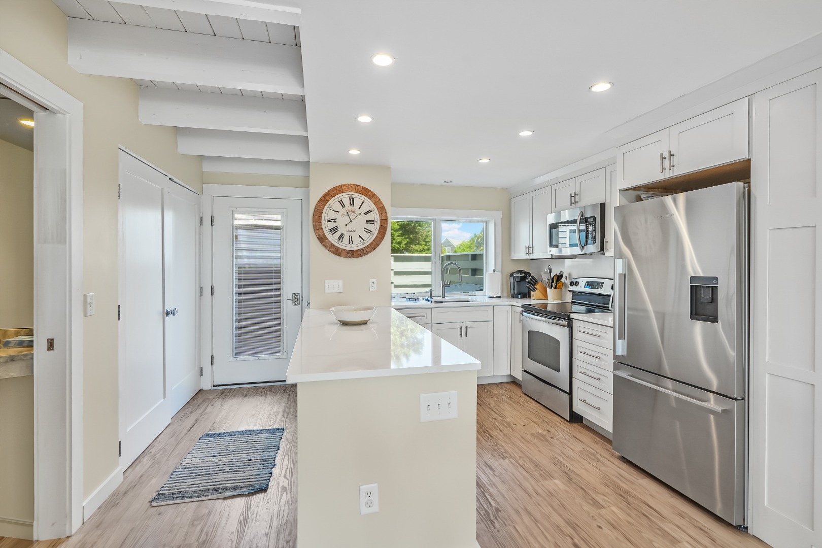 493 Katama Road, Unit E2 Edgartown, MA 02539 - Photo 9 of 29 a kitchen with white cabinets and stainless steel appliances
