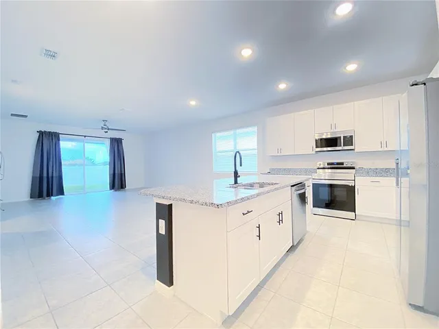 a kitchen with granite countertop a sink and stainless steel appliances