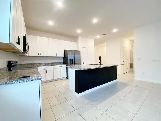 a kitchen with stainless steel appliances kitchen island granite countertop a sink and cabinets
