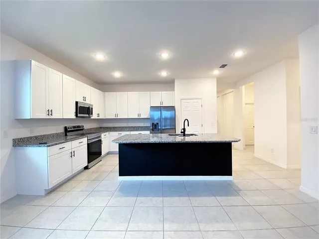a kitchen with granite countertop a sink and a stove
