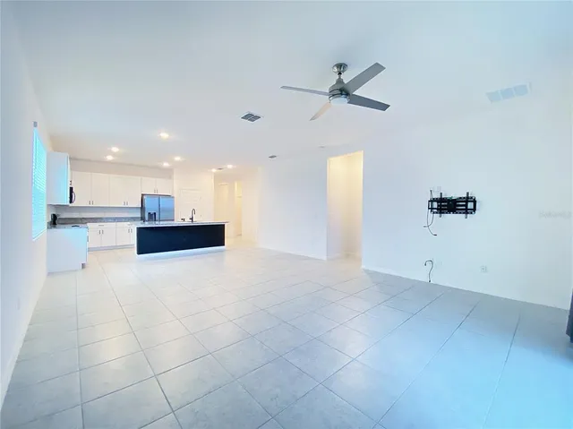 a view of an empty room with a kitchen