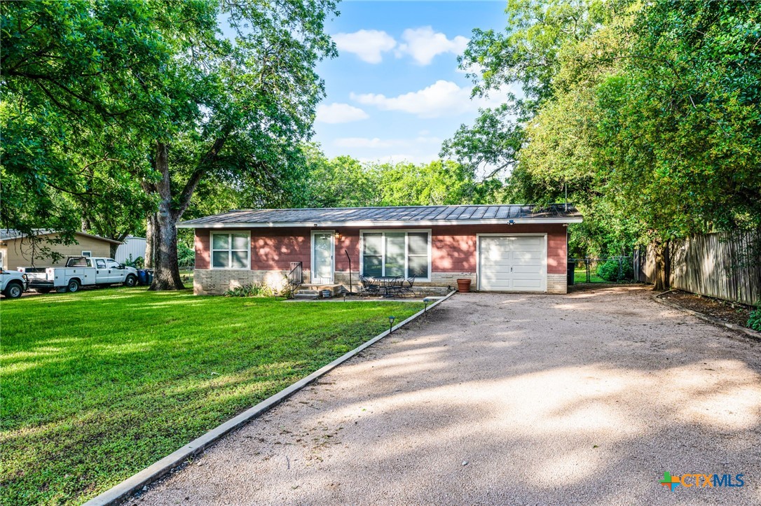a front view of a house with a garden and patio