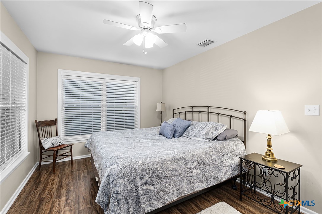 2052 Gruene Road New Braunfels, TX 78130 - Photo 19 of 33 a bedroom with a bed a chandelier and a window