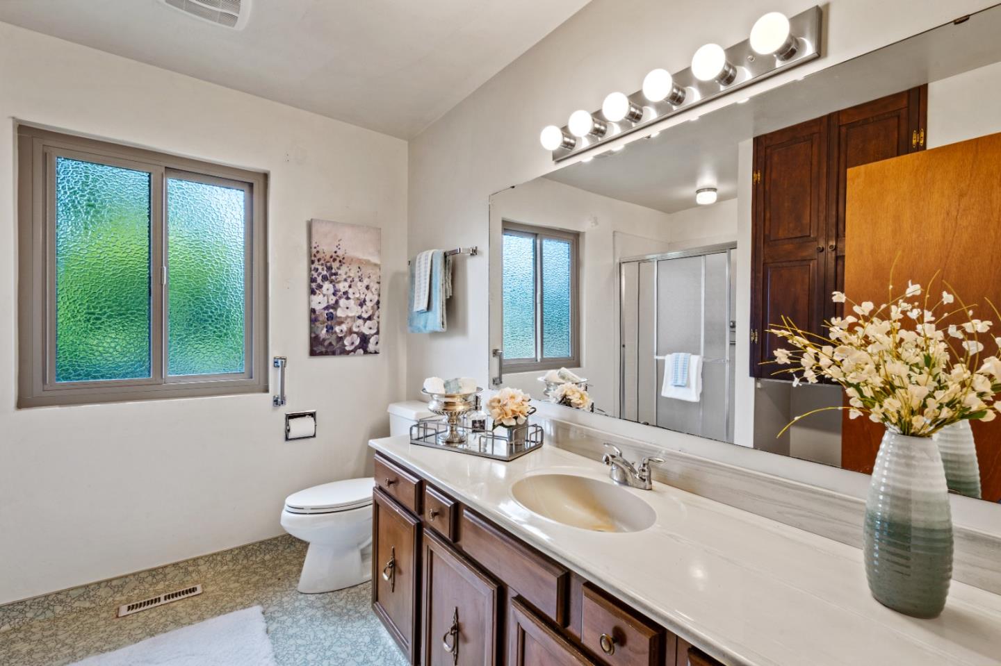 1088 Indian Village Road Pebble Beach, CA 93953 - Photo 16 of 22 a bathroom with a granite countertop sink a large mirror and a toilet