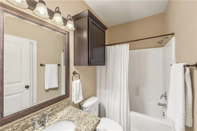 a bathroom with a tub shower and sink