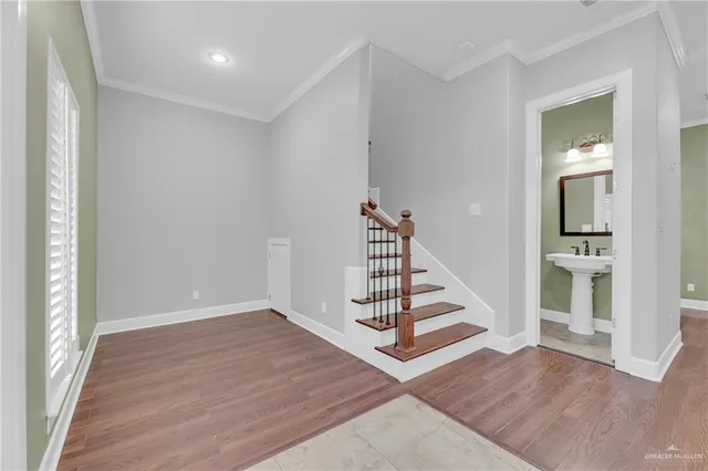 an empty room with wooden floor and entryway