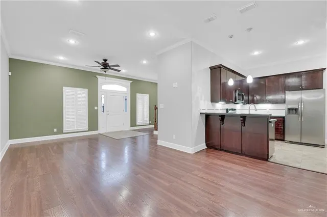 a open kitchen with stainless steel appliances granite countertop a stove top oven and refrigerator