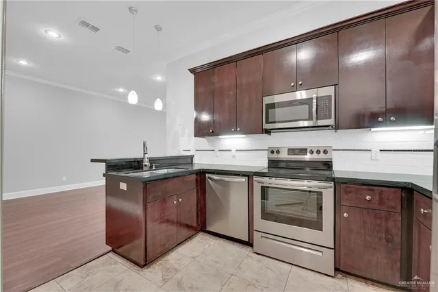 a kitchen with sink a microwave and cabinets