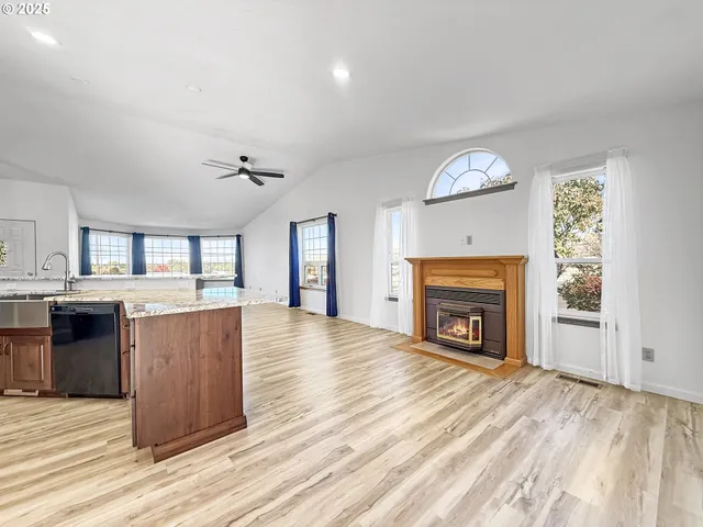 wooden floor fireplace and windows in an empty room