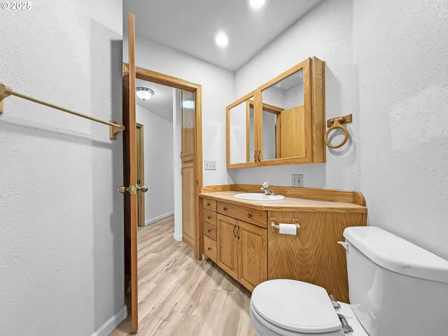 a bathroom with a granite countertop toilet sink and mirror