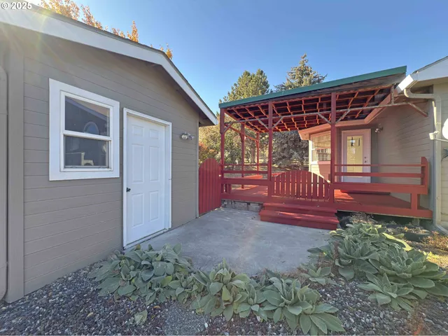 a view of a small house with wooden floor and fence