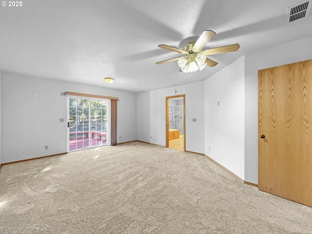 an empty room with closet and windows