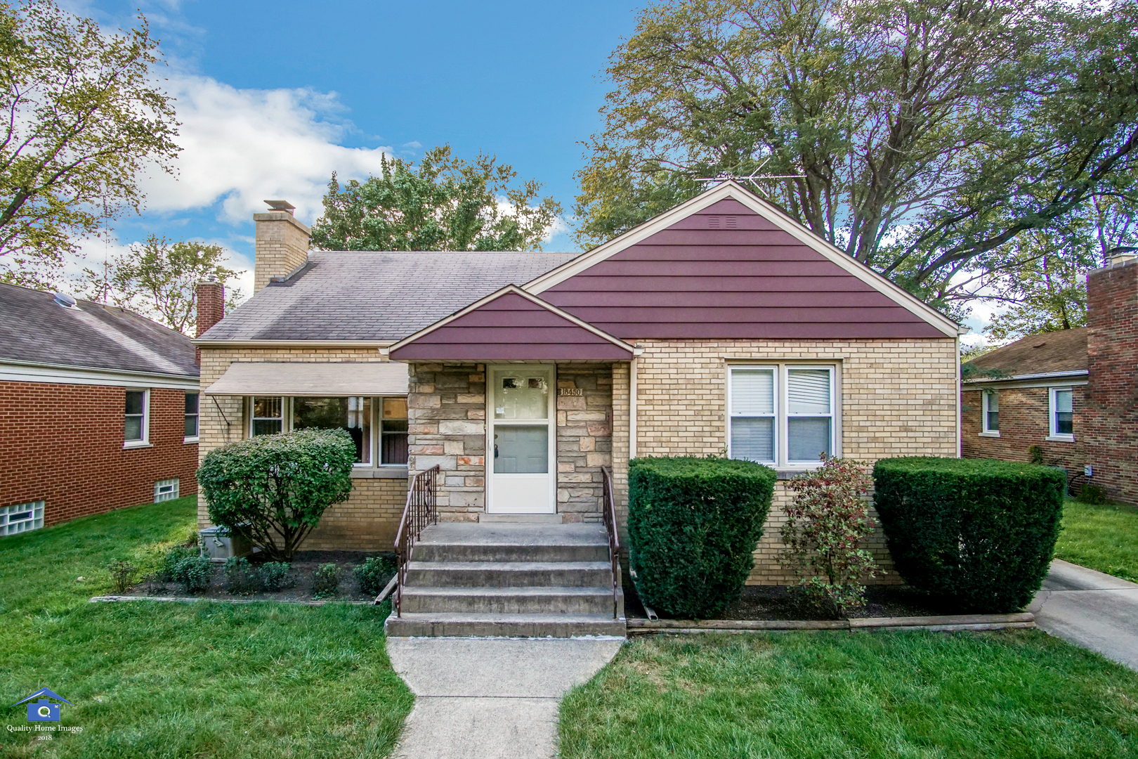 a front view of a house with a yard and outdoor seating