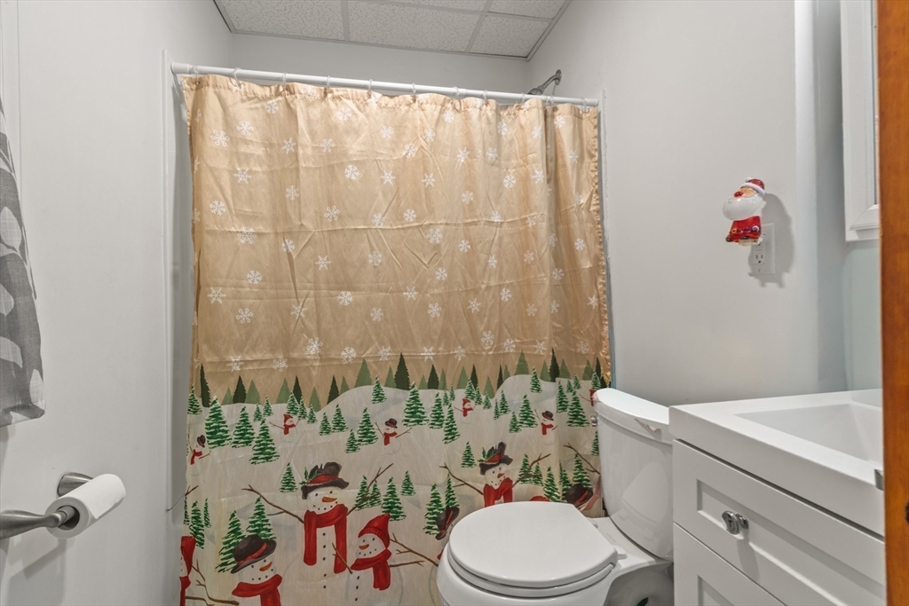 74 Forest Street Whitman, MA 02382 - Photo 13 of 32 a white toilet sitting next to a bathroom sink and a shower curtain
