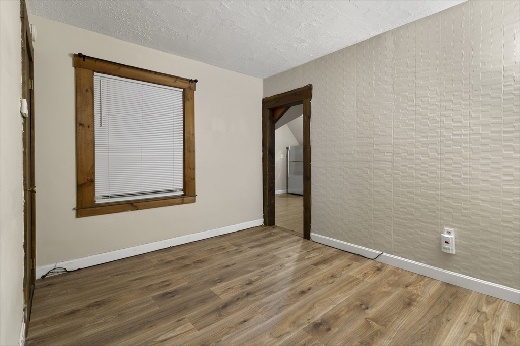 74 Forest Street Whitman, MA 02382 - Photo 24 of 32 a view of an empty room with wooden floor and a window