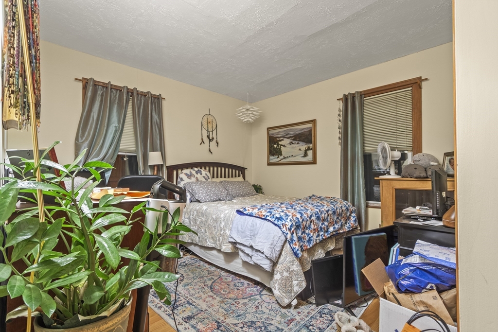 74 Forest Street Whitman, MA 02382 - Photo 10 of 32 a bedroom with a bed table flowerpot and window