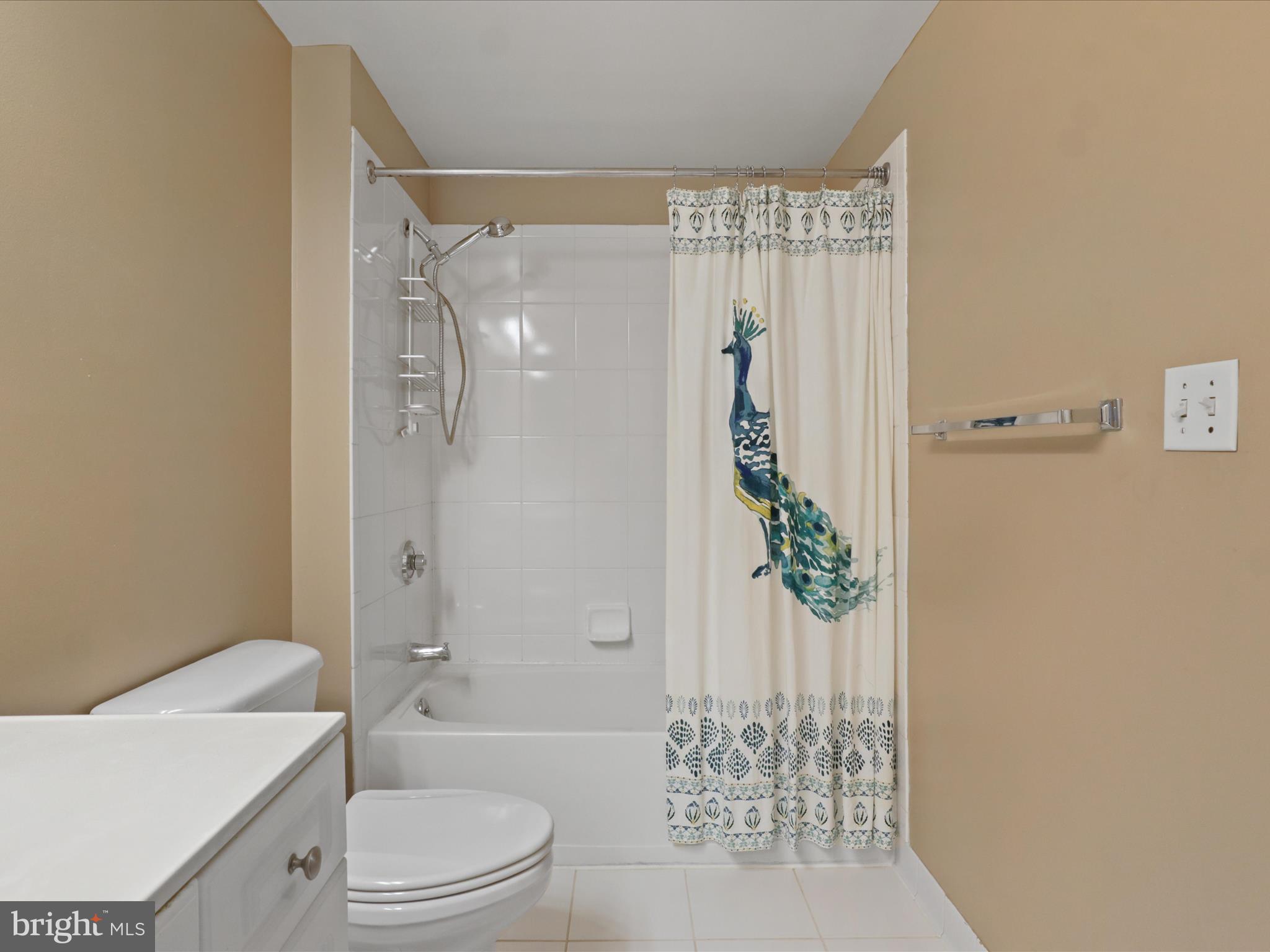 2726 Gallows Road, Unit 411 Vienna, VA 22180 - Photo 18 of 36 a bathroom with a granite countertop shower a toilet and a shower